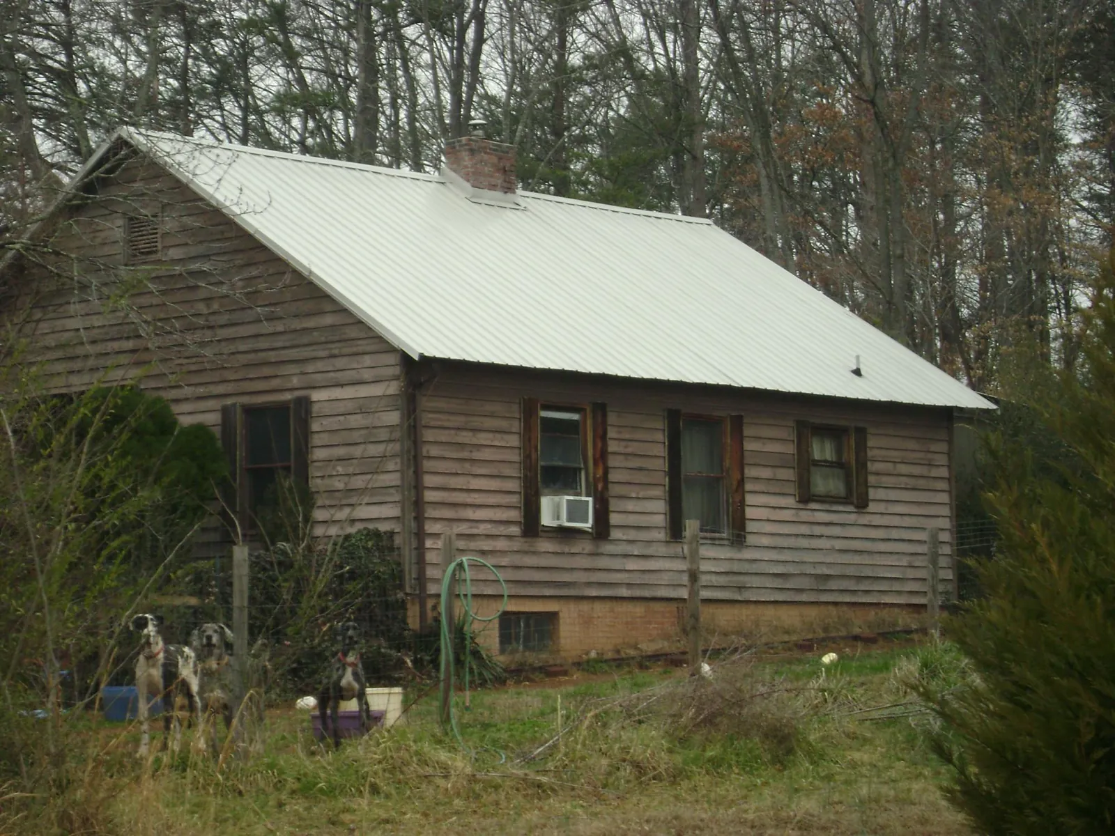 White metal roof on an old wood sided farmhouse, from a Metal Roof Installation job in Frederick
